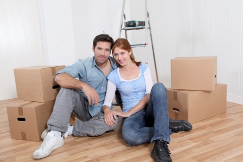 Local movers carrying furniture from a Mill Hill property